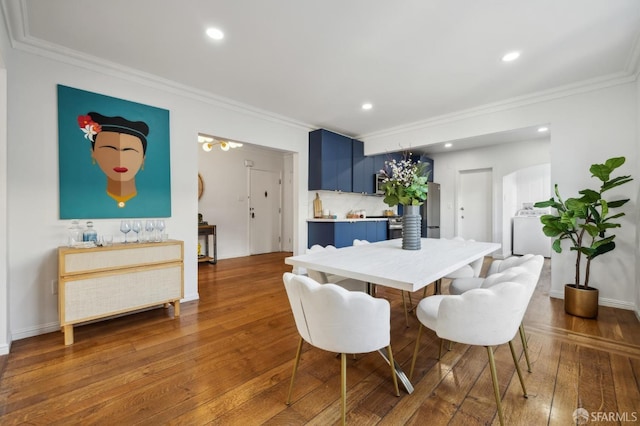 dining area featuring washer and dryer, crown molding, and dark hardwood / wood-style flooring