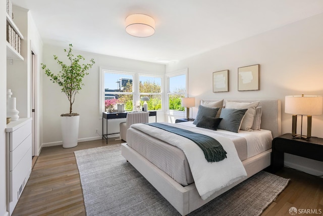 bedroom with light wood-type flooring and baseboards