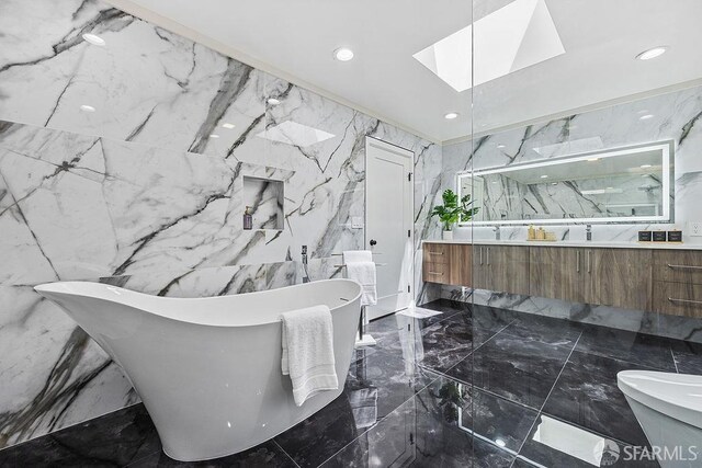 1098 Siler Pl, Berkeley, CA 94705 - bathroom featuring marble tiled floors, double vanity, a skylight, a soaking tub, and stone wall