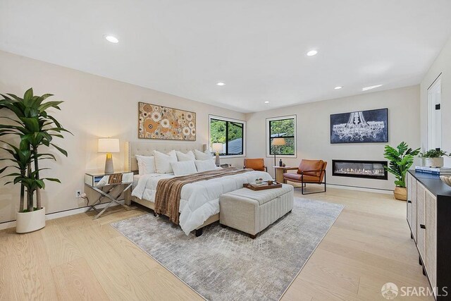 1098 Siler Pl, Berkeley, CA 94705 - bedroom with light wood-type flooring, recessed lighting, a glass covered fireplace, and baseboards