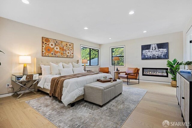 1098 Siler Pl, Berkeley, CA 94705 - bedroom featuring recessed lighting, a glass covered fireplace, light wood finished floors, and baseboards