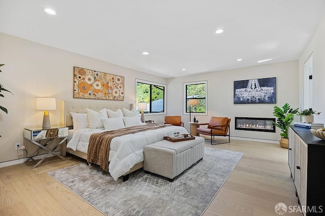 1098 Siler Pl, Berkeley, CA 94705 - bedroom featuring recessed lighting, a glass covered fireplace, light wood finished floors, and baseboards