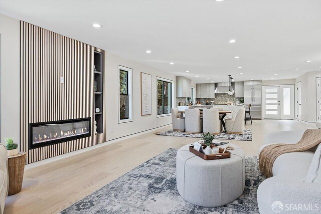 1098 Siler Pl, Berkeley, CA 94705 - living room with light wood-style flooring, plenty of natural light, recessed lighting, built in features, and a glass covered fireplace