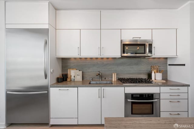 301 Main St Unit 34B, San Francisco, CA 94105 - kitchen featuring appliances with stainless steel finishes, white cabinetry, and decorative backsplash
