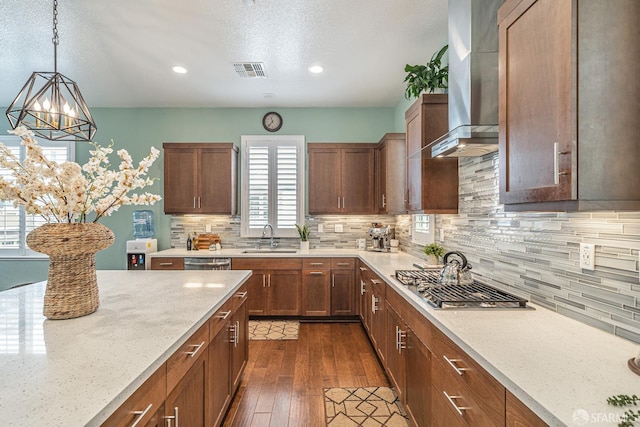 7240 Carneros Ln, Dublin, CA 94568 - kitchen featuring stainless steel appliances, wall chimney range hood, a chandelier, light stone counters, and dark wood-style floors