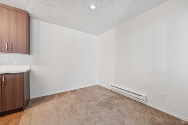 1201 Glen Cove Pkwy Unit 514, Vallejo, CA 94591 - unfurnished dining area with a baseboard radiator, a textured ceiling, light colored carpet, and baseboards