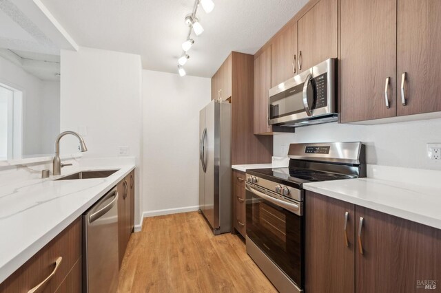 1201 Glen Cove Pkwy Unit 514, Vallejo, CA 94591 - kitchen with appliances with stainless steel finishes, a sink, light wood-style flooring, baseboards, and light stone counters