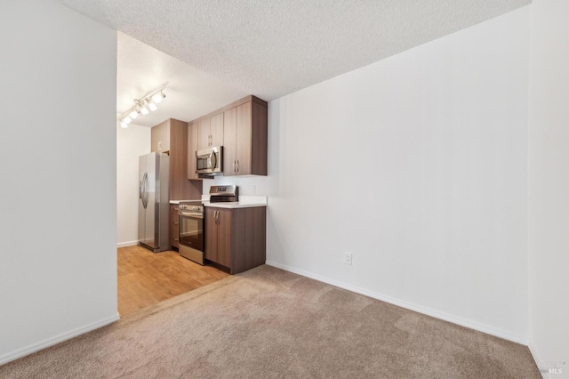 1201 Glen Cove Pkwy Unit 514, Vallejo, CA 94591 - kitchen featuring appliances with stainless steel finishes, light colored carpet, light countertops, baseboards, and a textured ceiling
