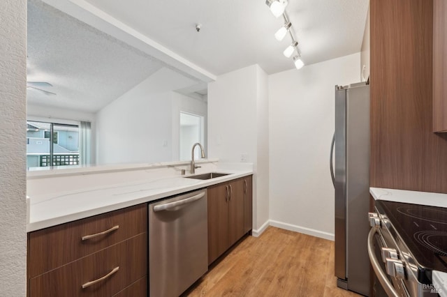 1201 Glen Cove Pkwy Unit 514, Vallejo, CA 94591 - kitchen with stainless steel appliances, a sink, light wood finished floors, baseboards, and a textured ceiling