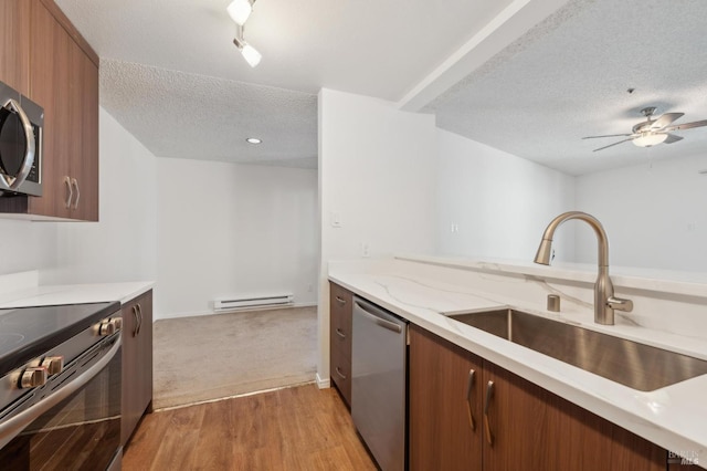 1201 Glen Cove Pkwy Unit 514, Vallejo, CA 94591 - kitchen featuring stainless steel appliances, a sink, a baseboard heating unit, a textured ceiling, and light wood-style floors