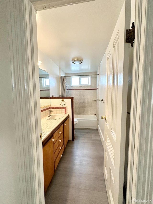 full bath featuring toilet, bathtub / shower combination, wood finished floors, and vanity