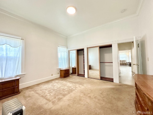 unfurnished bedroom featuring carpet flooring, crown molding, baseboards, and two closets