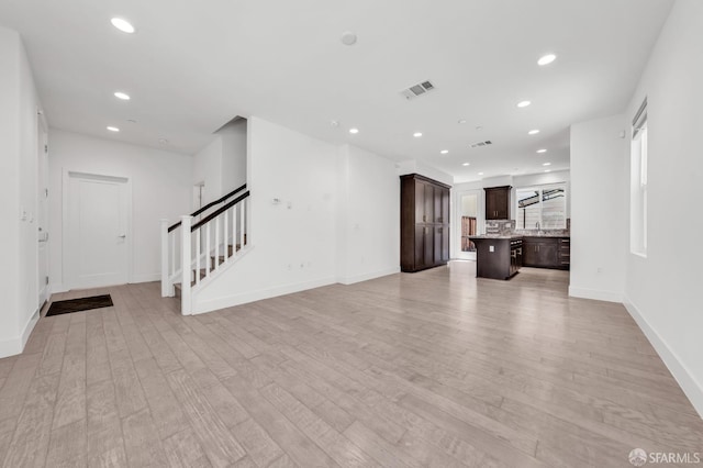 8534 Jetty Way, Newark, CA 94560 - unfurnished living room with stairway, light wood-style flooring, recessed lighting, baseboards, and a sink