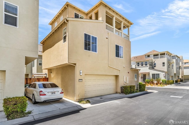 8534 Jetty Way, Newark, CA 94560 - view of front of property featuring an attached garage, stucco siding, a balcony, driveway, and a residential view