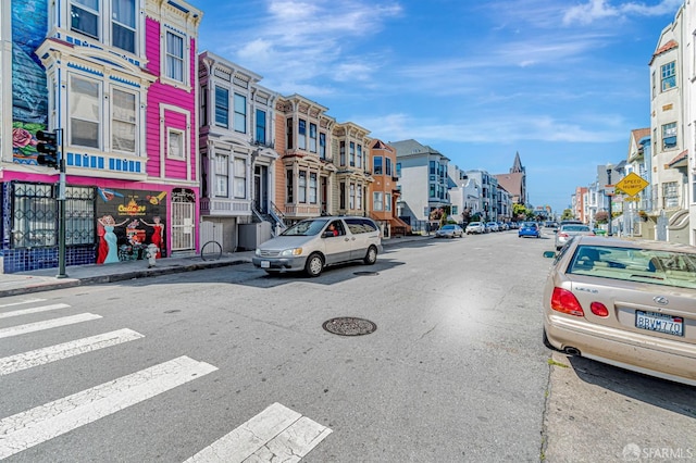 3230-3236 24th St, San Francisco, CA 94110 - view of asphalt road featuring a residential view, sidewalks, curbs, street lights, and traffic signs