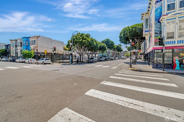 3230-3236 24th St, San Francisco, CA 94110 - view of asphalt street featuring street lights, sidewalks, curbs, and traffic lights