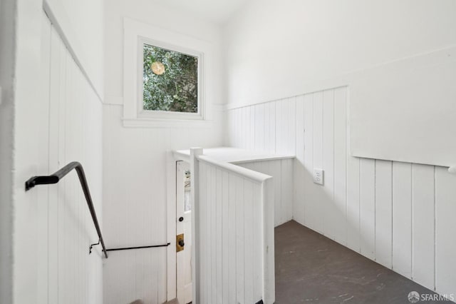 interior space featuring concrete flooring and wainscoting