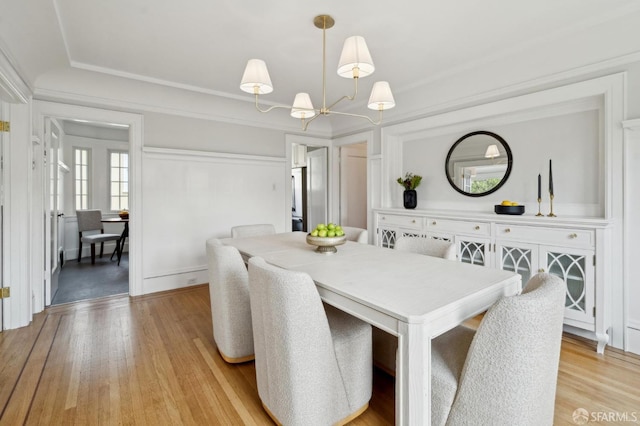 dining area featuring light wood-type flooring and a notable chandelier