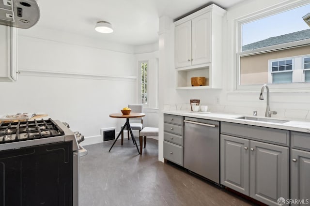 kitchen with stainless steel appliances, a sink, plenty of natural light, and gray cabinets