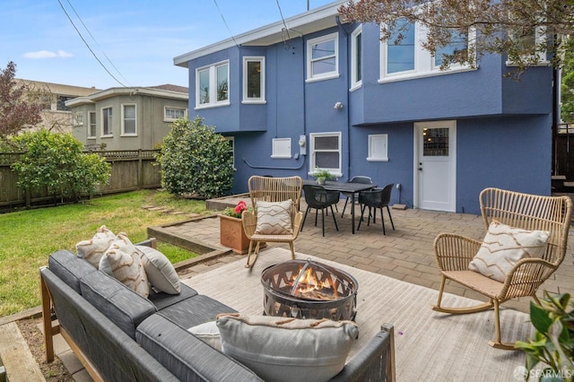 rear view of house featuring a wooden deck, fence, a yard, outdoor dining space, and stucco siding