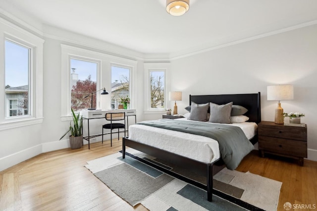 bedroom featuring baseboards, multiple windows, and wood finished floors