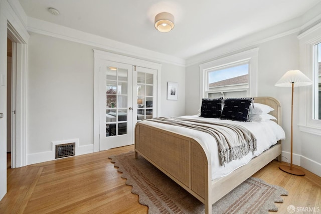 bedroom with access to outside, french doors, baseboards, wood finished floors, and visible vents