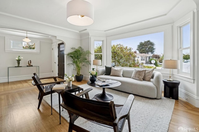 sunroom featuring arched walkways and a wealth of natural light