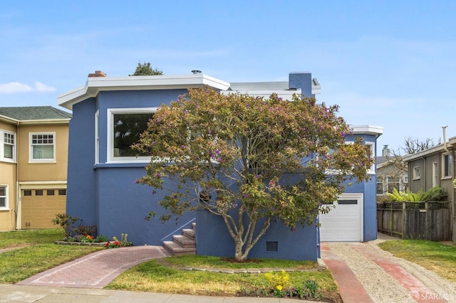 view of front of home featuring an attached garage, fence, driveway, and stucco siding