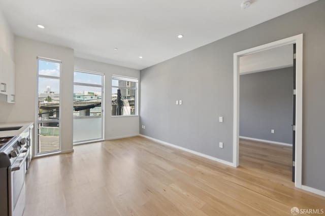 kitchen featuring white cabinetry, sink, stainless steel range, and light hardwood / wood-style floors