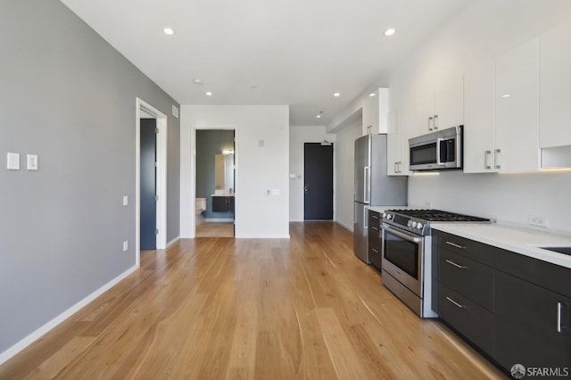 kitchen featuring appliances with stainless steel finishes, light hardwood / wood-style flooring, and white cabinets