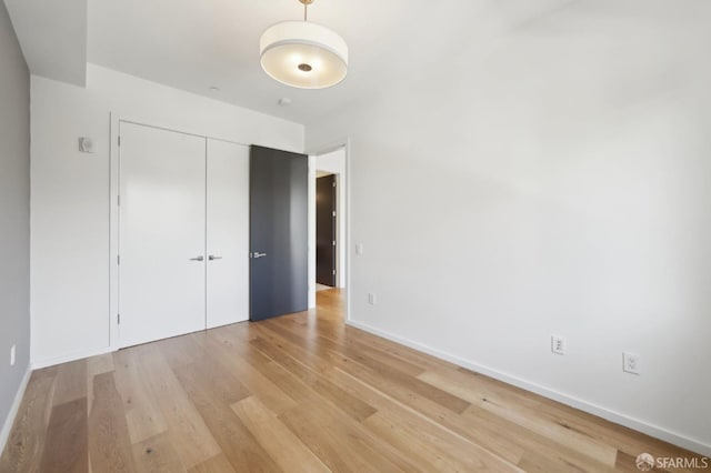 unfurnished bedroom featuring light hardwood / wood-style flooring and a closet