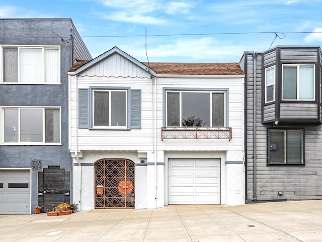7014 Fulton St, San Francisco, CA 94121 - view of front facade featuring concrete driveway, a garage, stucco siding, and a balcony