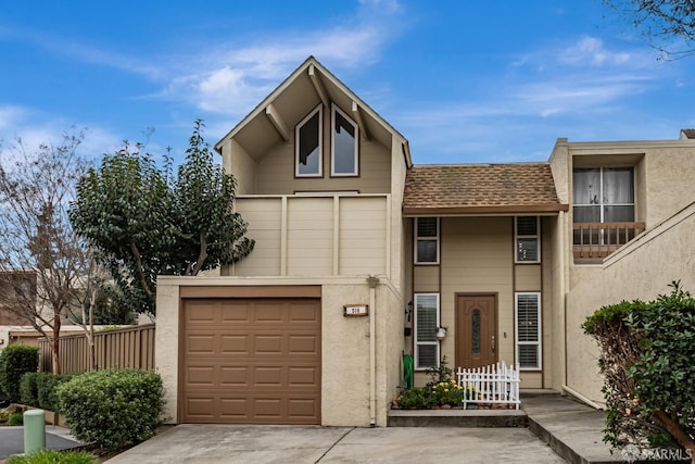 view of property featuring driveway, a shingled roof, an attached garage, and stucco siding