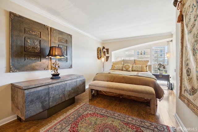 bedroom with crown molding, baseboards, and wood finished floors