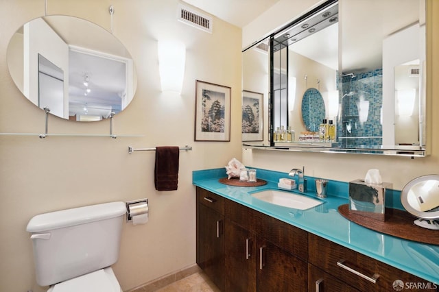 bathroom featuring visible vents, a shower, vanity, baseboards, and toilet