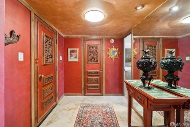 foyer with baseboards and ornamental molding