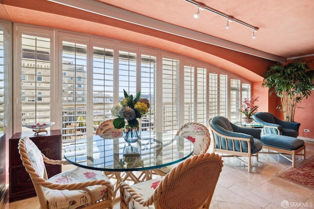 sunroom featuring track lighting and a healthy amount of sunlight