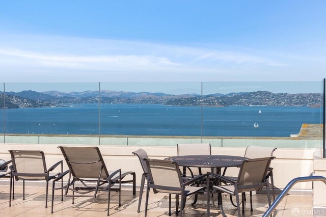 view of patio with a water and mountain view