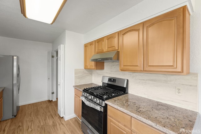 kitchen with tasteful backsplash, light brown cabinets, appliances with stainless steel finishes, light stone countertops, and light hardwood / wood-style floors