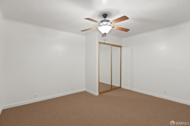 unfurnished bedroom with crown molding, a closet, ceiling fan, and carpet flooring