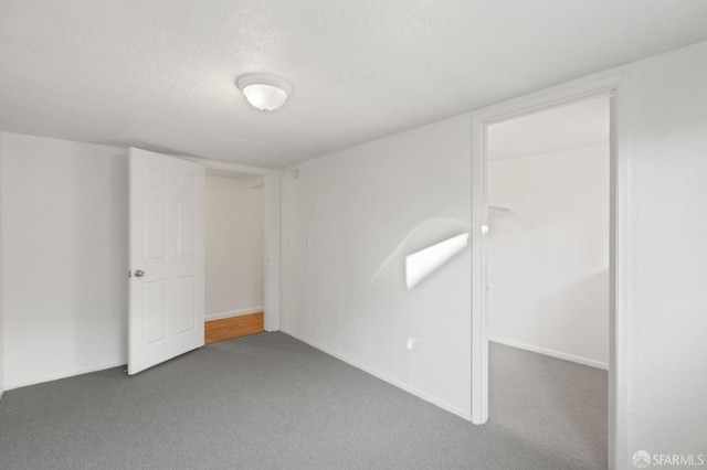 carpeted spare room featuring a textured ceiling