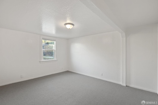 spare room with a textured ceiling and carpet flooring