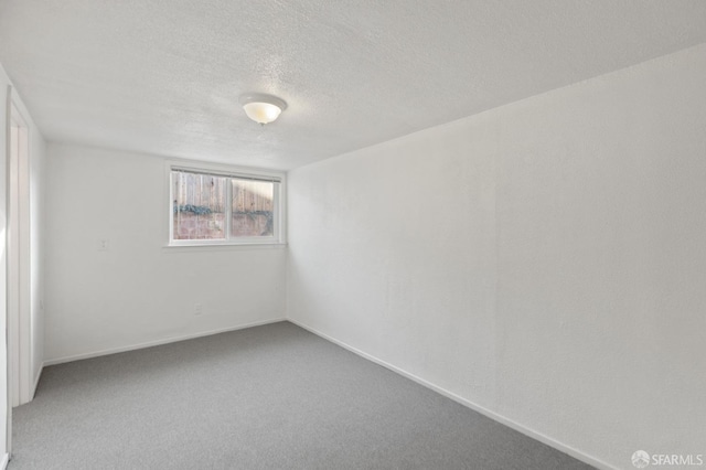 carpeted spare room with a textured ceiling