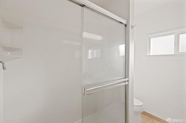 bathroom with an enclosed shower and toilet