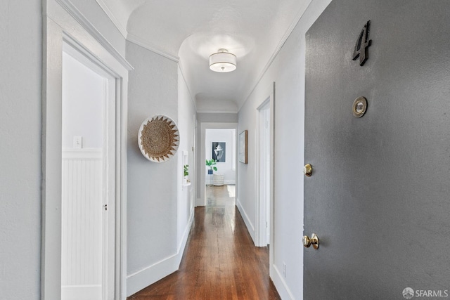 corridor featuring ornamental molding and dark hardwood / wood-style floors