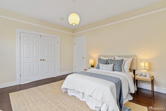 bedroom with dark hardwood / wood-style flooring and a closet