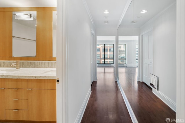 hall featuring ornamental molding, sink, and dark hardwood / wood-style flooring