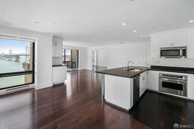 kitchen featuring dark hardwood / wood-style floors, sink, white cabinets, a water view, and appliances with stainless steel finishes