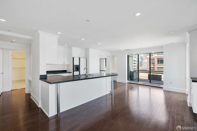 kitchen featuring ornamental molding, sink, white cabinetry, white fridge with ice dispenser, and dark hardwood / wood-style flooring