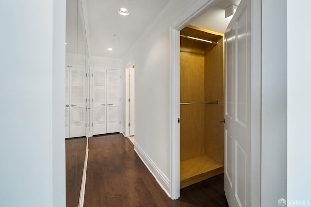 hallway with ornamental molding and dark hardwood / wood-style floors